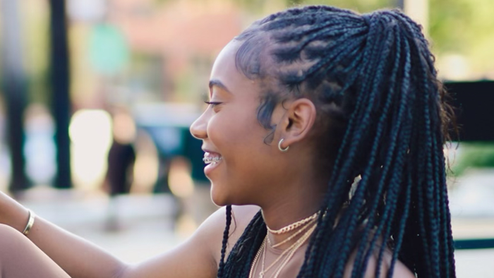 Woman with braided hair smiling outdoors